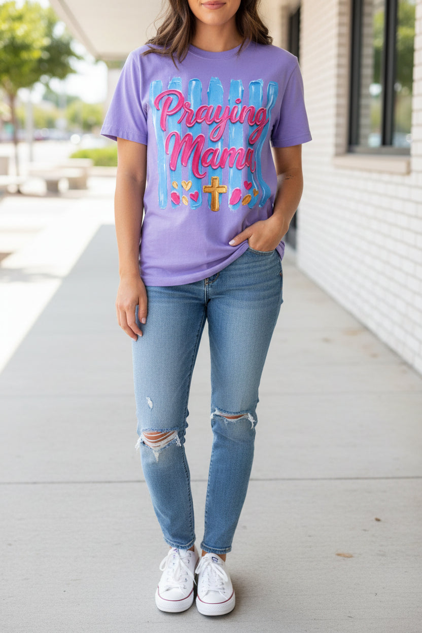 Purple t-shirt with 'Praying Mama' text and graphics on a white background